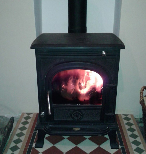 Wood burning stove with flames from the fire visible through the glass