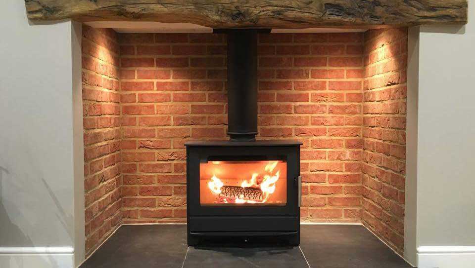 Multi fuel woodburning stove with a roaring fire a light